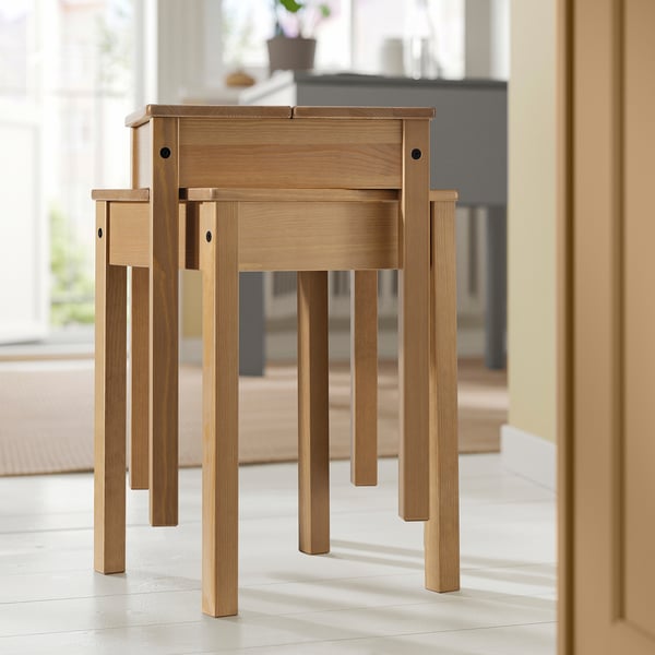Light brown HÄGERNÄS stool with handles, splayed legs, pine, stackable.