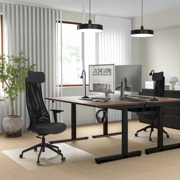 Modern office with JÄRVFJÄLLET chairs and adjustable desks, dual monitors, pendant lights, blinds, plant.