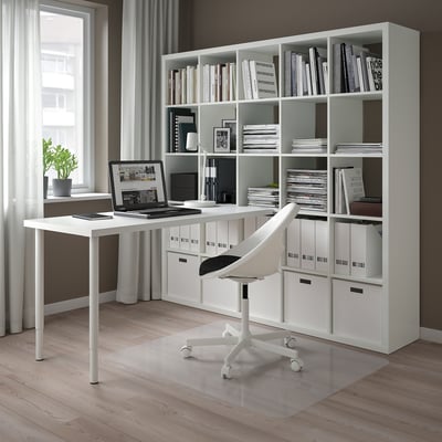 Modern home office with KALLAX storage, desk, laptop, chair, and large window.