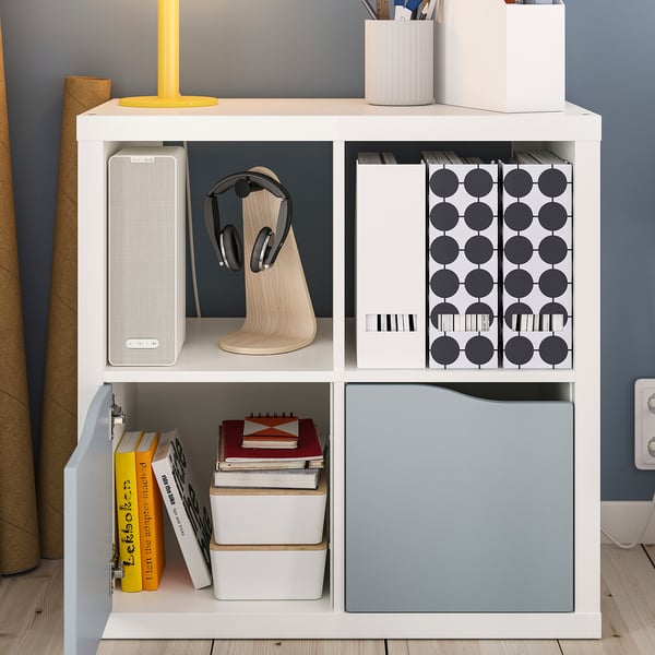 KALLAX storage unit with compartments for organising books, speakers, headphones, and boxes. Tidy and clutter-free setup.