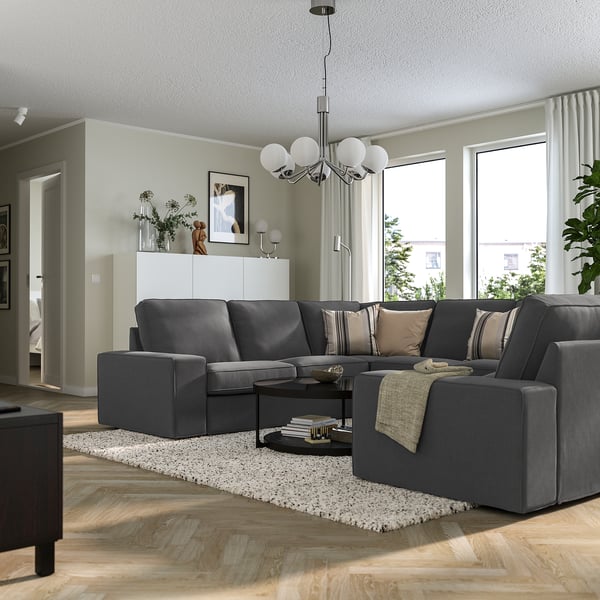 Modern living room with KIVIK sofa, wooden floors, and large windows.
