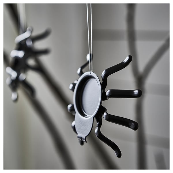 Spider-shaped tealight holder with extended legs, designed for decorative hanging or use with a lit tealight.