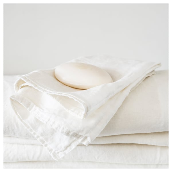 White folded cloth under round dish, minimalist bedding setup.