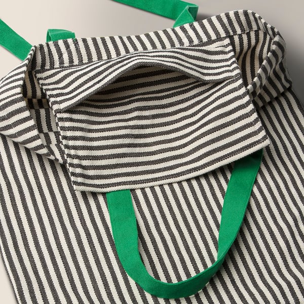 Striped tote bag with green handles, open showing inside pocket.