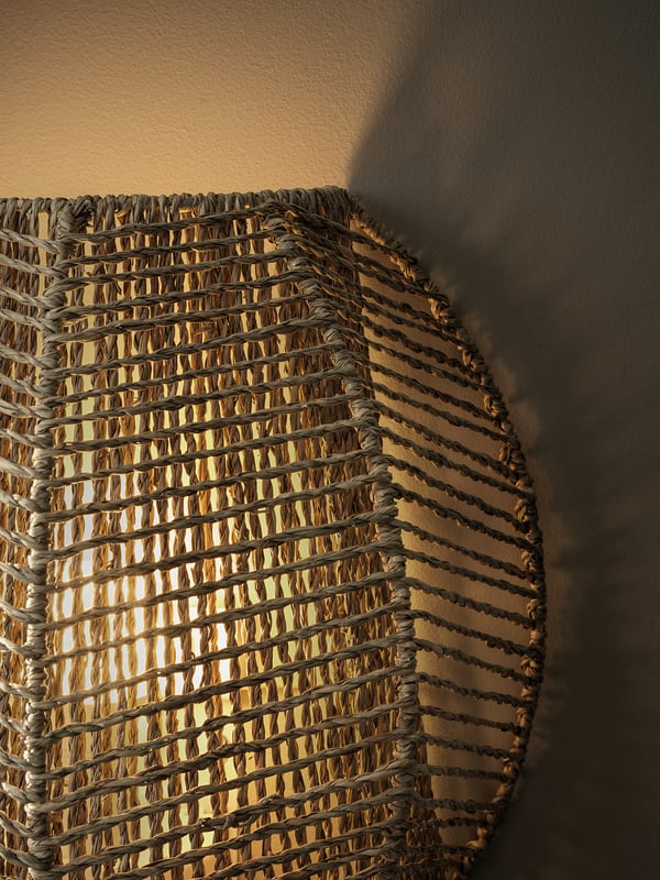 MÅNALG wall lamp, braided shade casts warm, decorative light.