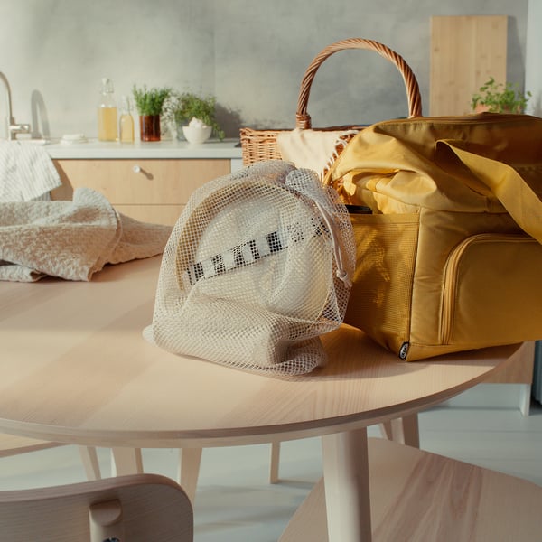 MARULK yellow picnic set on wooden table, includes mesh bag and tray, near brown bags.