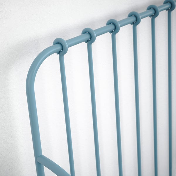 Modern turquoise metal bed frame, vertically slatted with sturdy, smooth railings.