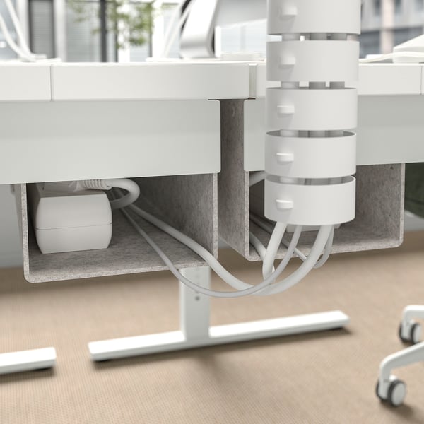 A height-adjustable desk with a cable management tray and hooks for organising accessories.