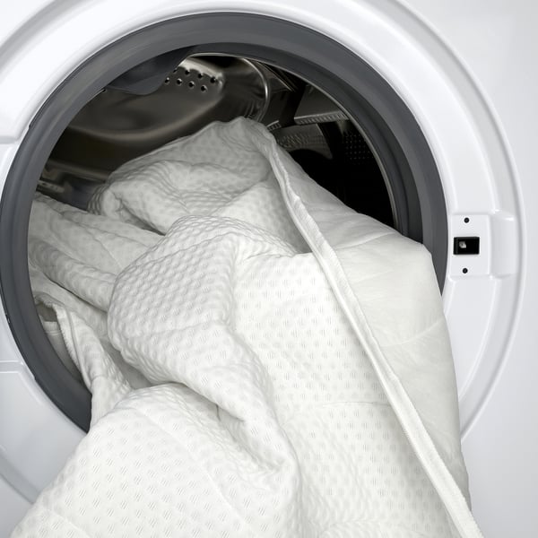 White washing machine with comfy, quilted duvet.