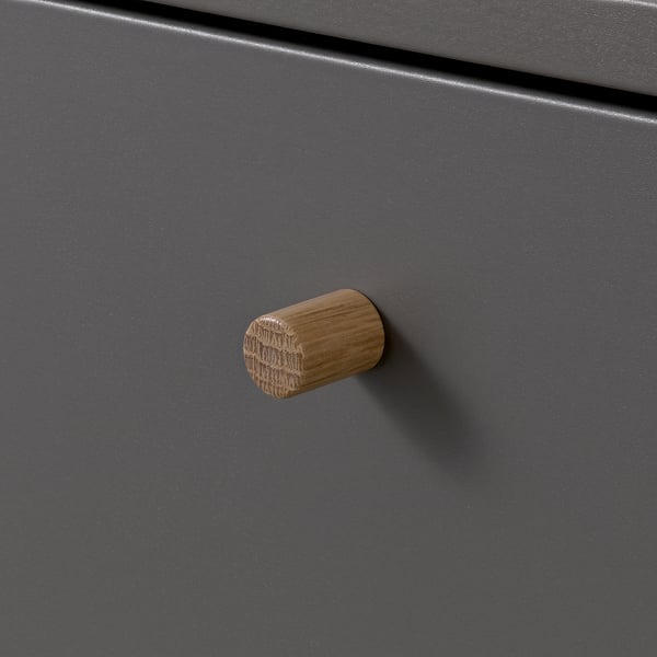 Handcrafted wooden knobs on matte grey cabinet door. Rounded shape with visible wood grain. Stylish, durable, and functional design.