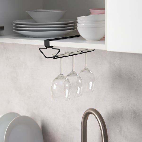 Under-shelf wine glass rack holds three glasses, saving cabinet space. Black metal design securely hangs glasses from shelf.