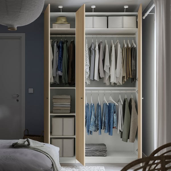 Open wardrobe with clothes, shelves, and storage boxes, mounted on wall.
