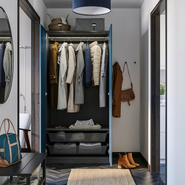 Modern open closet with coat hangers and shelves, brown coat, handbag and boots on floor, blue wardrobe frame.
