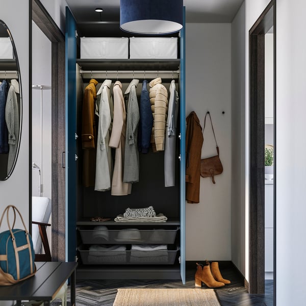 Open wardrobe with coats, shelves, and storage bins, showing organised closet space.