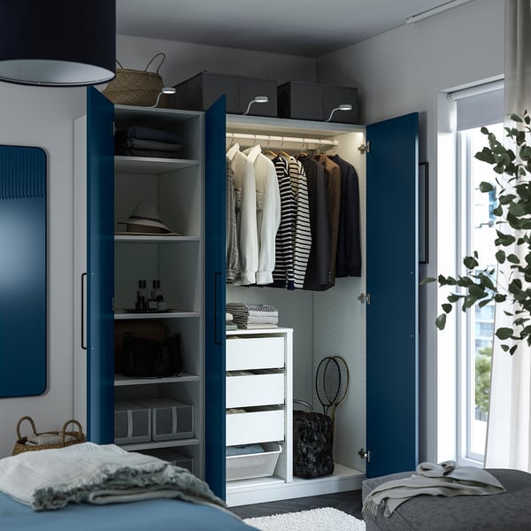 Blue PAX wardrobe, open showing clothes, shelves, drawers, and interior storage boxes.