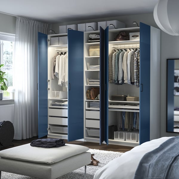Modern bedroom with blue wardrobe, shelves, drawers, lighting, and mesh basket.
