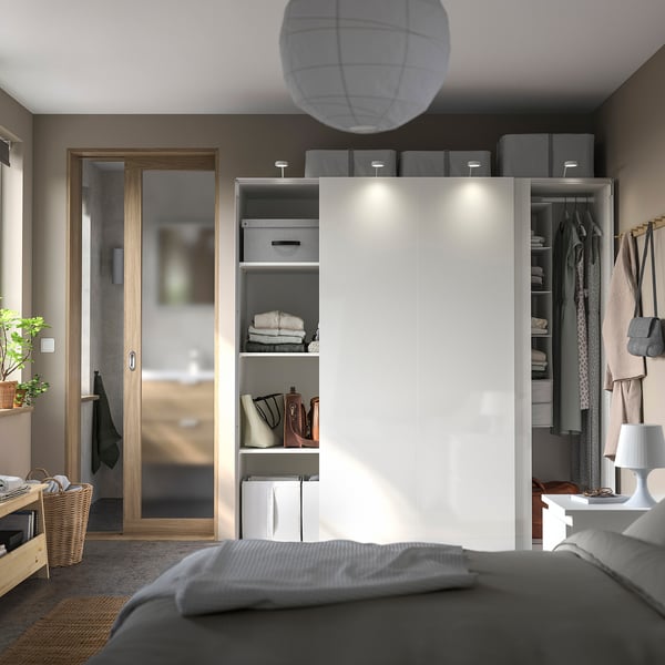 Modern bedroom with IKEA PAX wardrobe. Sliding doors, lights, organised storage. Grey and white minimalist design.