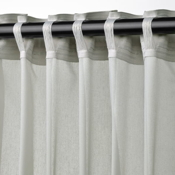 Light grey sheer curtains with tabs for hanging, allowing privacy while letting in filtered light.