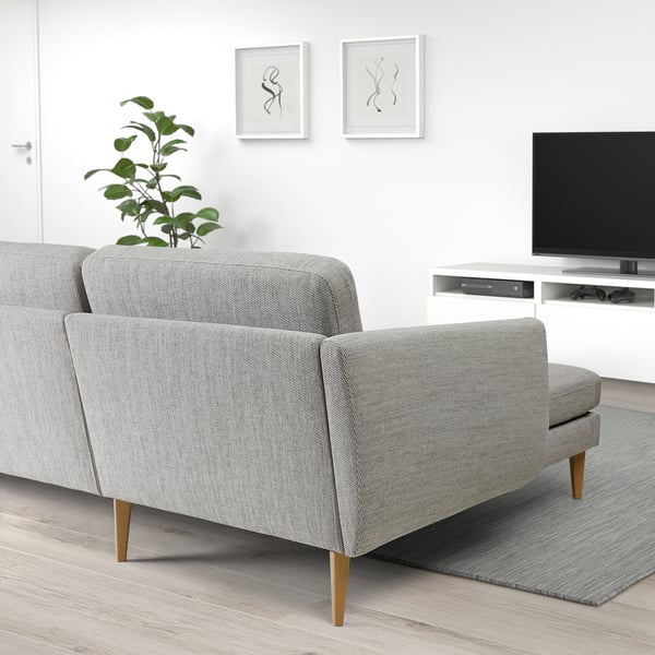 Modern minimal living room with grey sofa, plant, tv, and art.