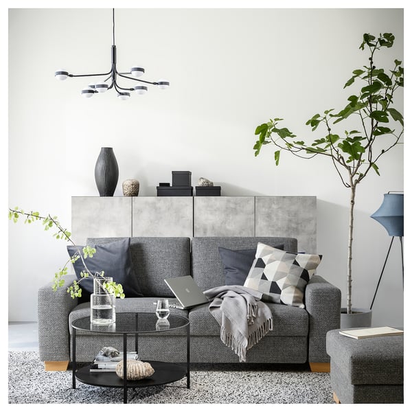 Modern grey SÖRVALLEN sofa with minimalist design, wooden legs, cushions, and indoor plants.