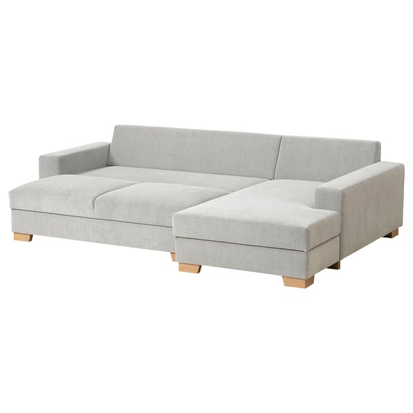 A modern, light grey SÖRVALLEN sofa with a chaise longue. It has a minimalist design with wooden legs and cushioned seating.