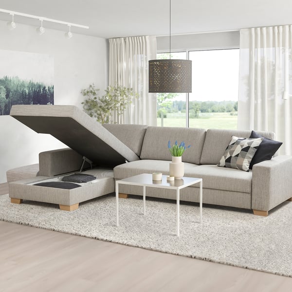 Minimalist living room with sofa, tray, storage, coffee table, windows, curtains, light, plant, pillows.