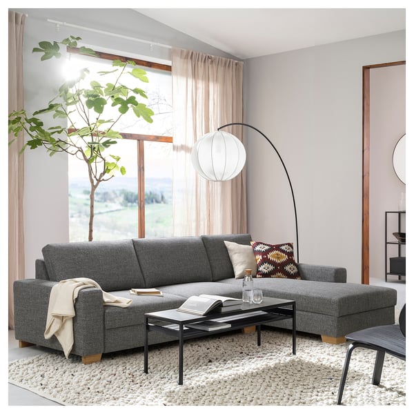 Modern living room with grey sörlvallen sofa, black coffee table, curved lamp, large window, and plant.
