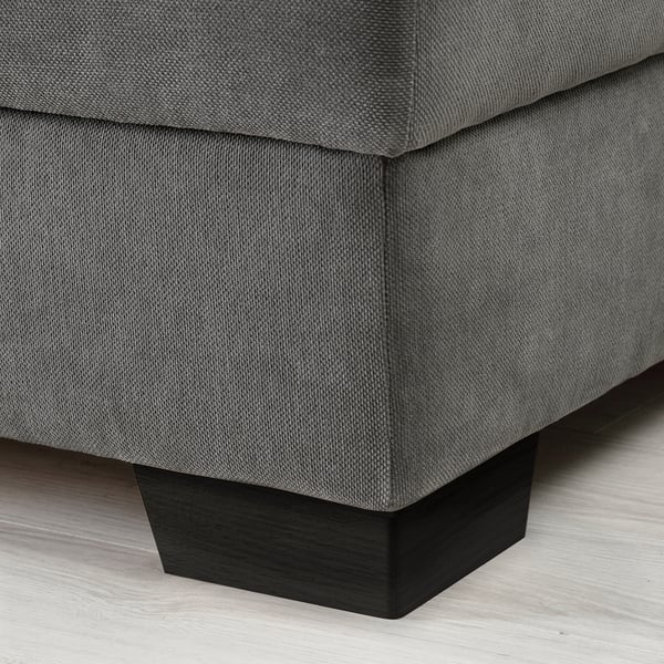 Close-up view of SÖRVALLEN sofas corner. Dark grey fabric, sturdy wooden legs, clean lines.