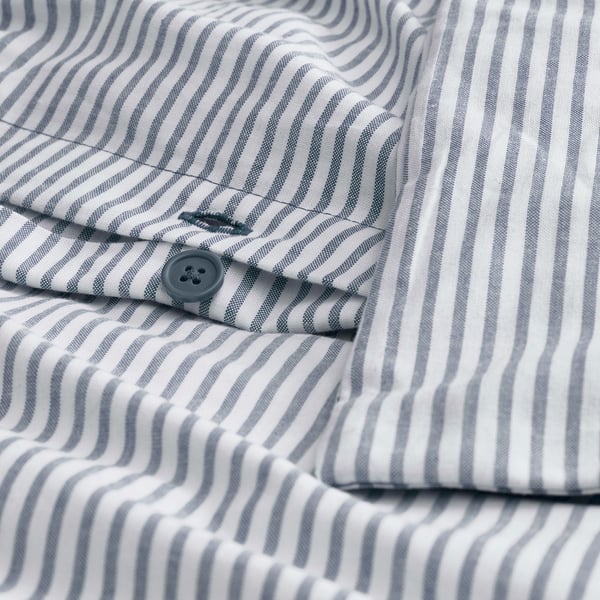 Close-up of striped shirt with collar folded back, showing button and thread detail.