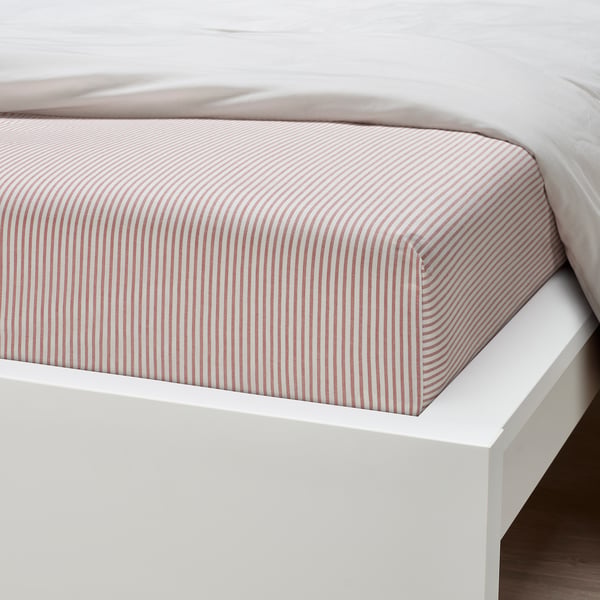 A neatly made bed with a red and white striped fitted sheet on a clean white bed frame.