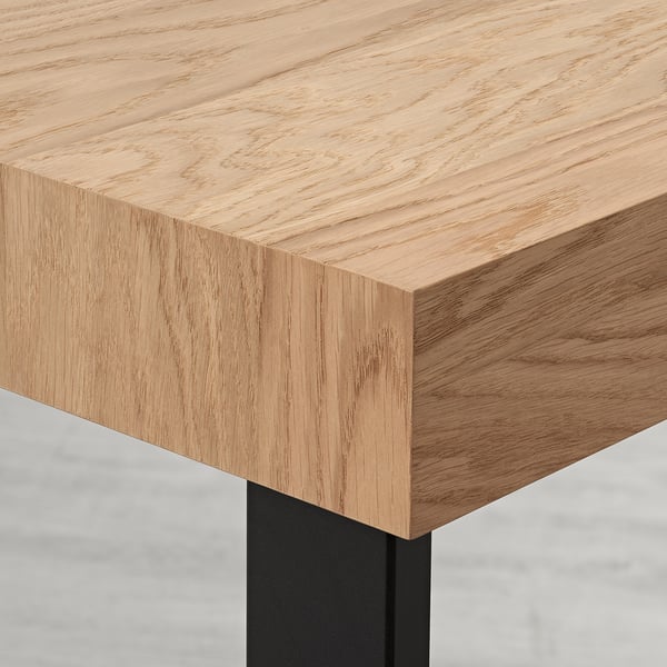 Modern extendable dining table with sleek oak veneer top and sturdy metal base, showcasing quality craftsmanship.