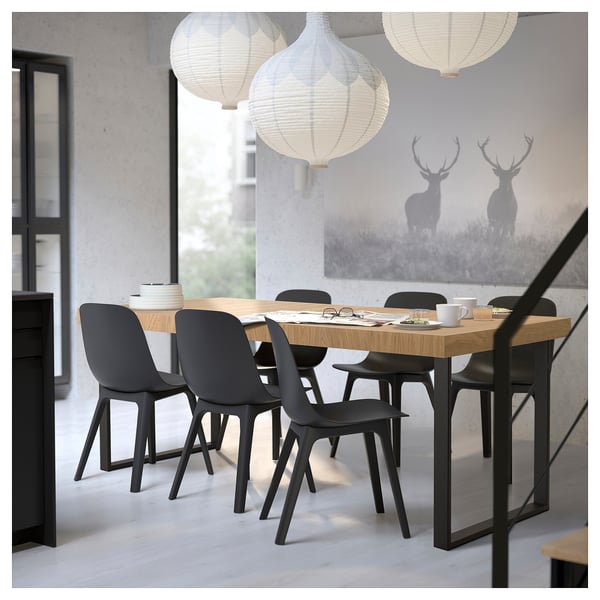 Modern dining room with extendable wood table, black chairs, deer mural, 3 paper lanterns.