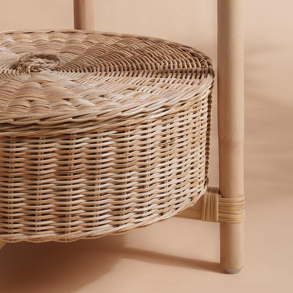 Close-up of a beautifully woven round rattan tray. Intricate weave pattern, natural finish, and neat edges visible. Supported by a light wooden frame.