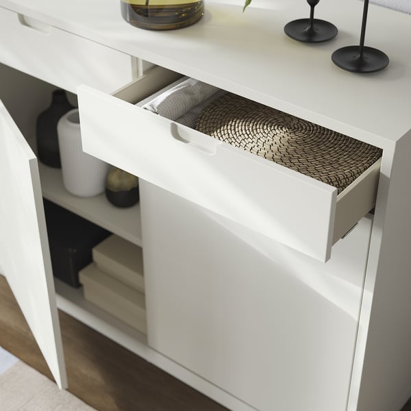 White modern cabinet with woven drawer, sleek handles.