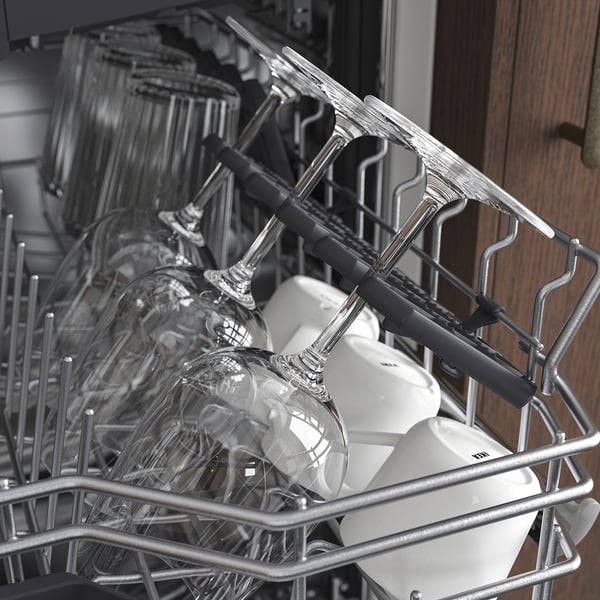 Black and white an open dishwasher filled with clean dishes, including wine glasses and cutlery, arranged in racks.