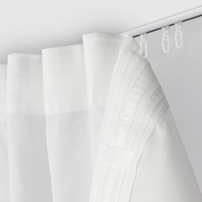A bright white shower curtain hangs from three hooks, serving as a bathroom divider.