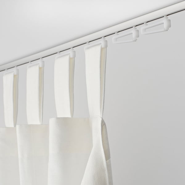 White curtains hang from a track, with clips holding them in place. Simple, clean, and minimalistic.