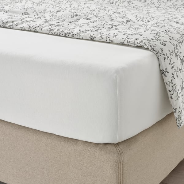 White bed sheet set with black floral pattern; fitted sheet with elastic for secure fit on mattress up to 26 cm thick.