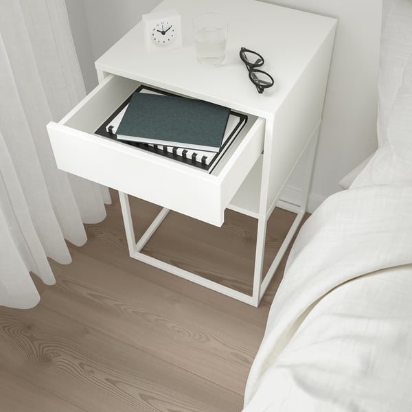Bedside table with open drawer revealing book and silent-closing mechanism.