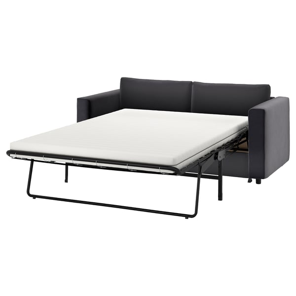 A black and grey VIMLE sofa-bed with a pull-out white mattress. It has a modern design with clean lines and supportive cushions.