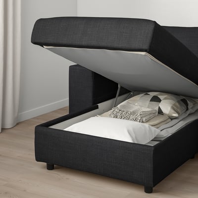 Image shows a dark grey VIMLE sofa with open storage under seat, revealing bedding and pillows inside.