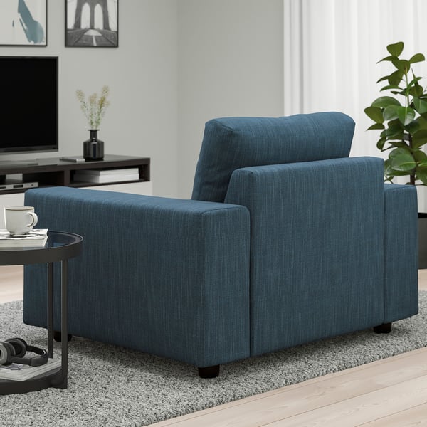 Blue fabric sofa in living room with wooden floor and coffee table.