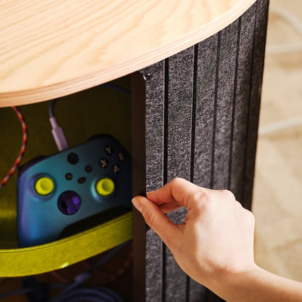 Drawer of YXSTABY gaming table opens to reveal a controller and charging cords, showing organised gaming accessory storage.