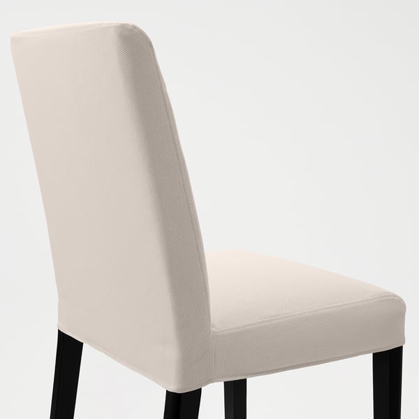 Stylová jídelní židle s elegantním béžovým čalouněním a robustními černými nohami pro pohodlí a podporu.