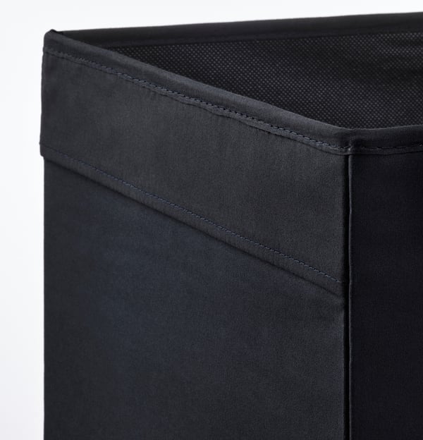 Detailní záběr na robustní, dobře prošívanou černou látkovou úložnou krabici; ukazuje kvalitu a design.