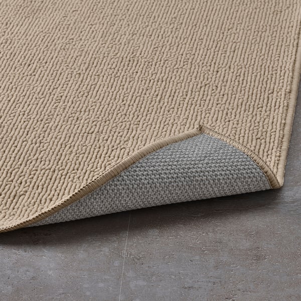 Koupelnová předložka s béžovým a šedým strukturovaným povrchem. Latexový podklad zabraňuje sklouznutí.
