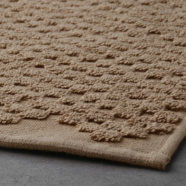 Béžová, strukturovaná, vysoce kvalitní bavlněná koupelnová předložka se složitým vzorem a měkkým froté povrchem, která poskytuje pohodlí a vysokou absorpci.