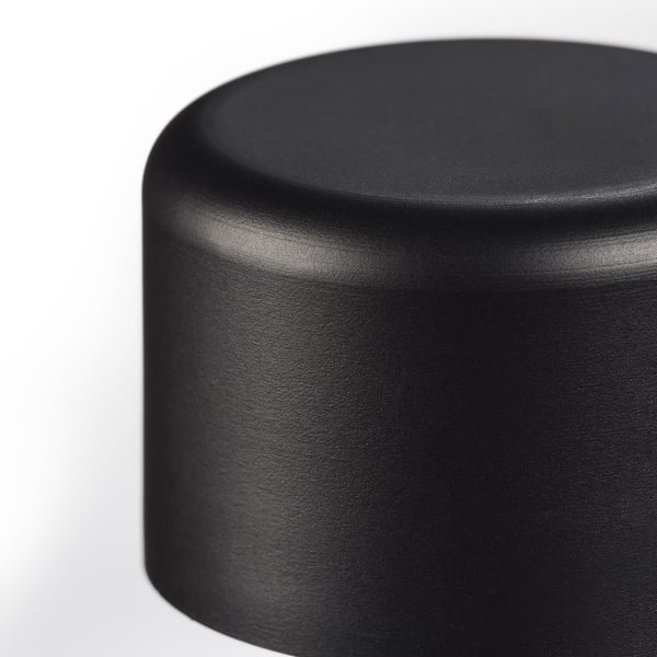 Zobrazuje detailní záběr elegantního černého válcovitého vrcholu z recyklovaného plastu, což ukazuje jeho hladkou, elegantní texturu a kvalitu.