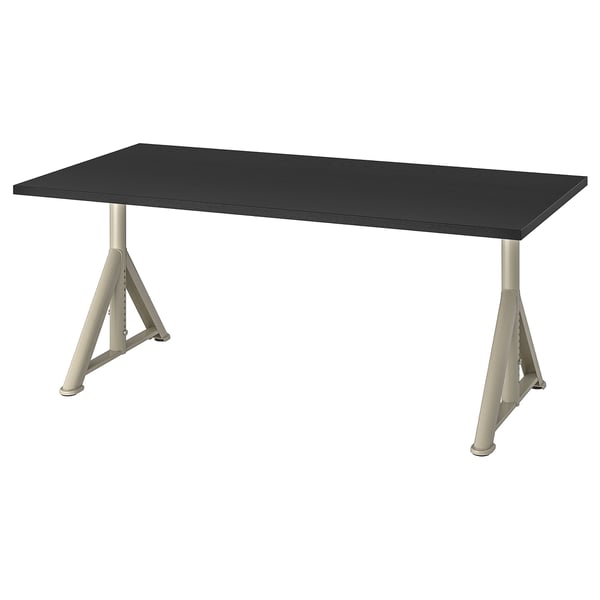 Psací stůl IKEA IDÅSEN s černou deskou a nastavitelnými stříbrnými nohami. Je obdélníkový a má moderní, minimalistický design se zabudovaným vedením kabelů.