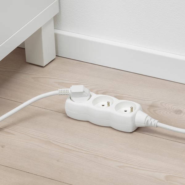 Bílá přepěťová ochrana na podlaze.